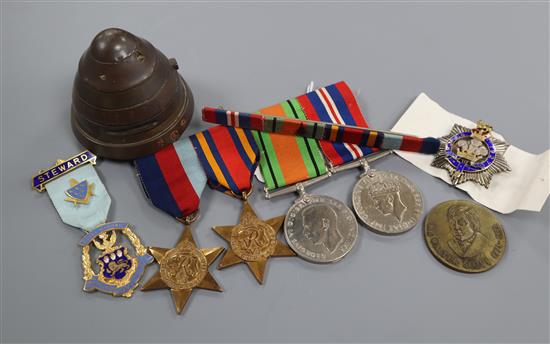 A set of World War II medals, badge and one other coin and shell cap